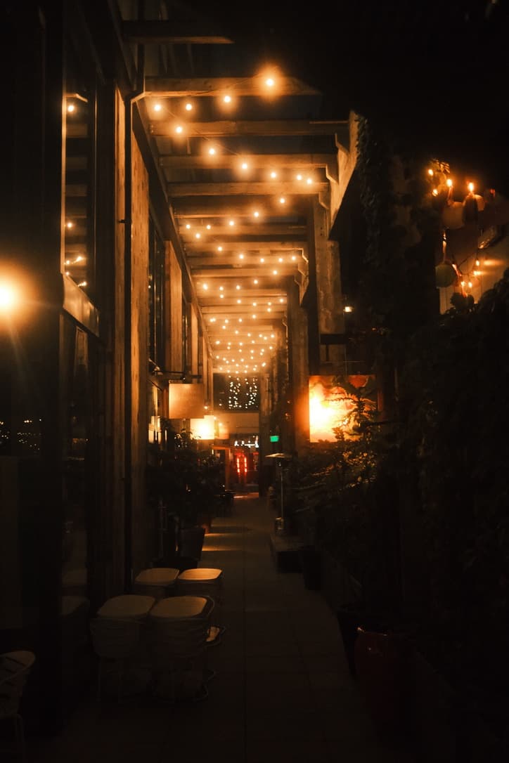 Restaurant patio lit by warm string lights at night