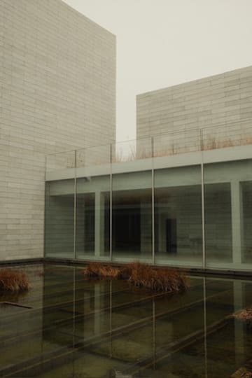 Reflecting pool between pale modern buildings on an overcast day